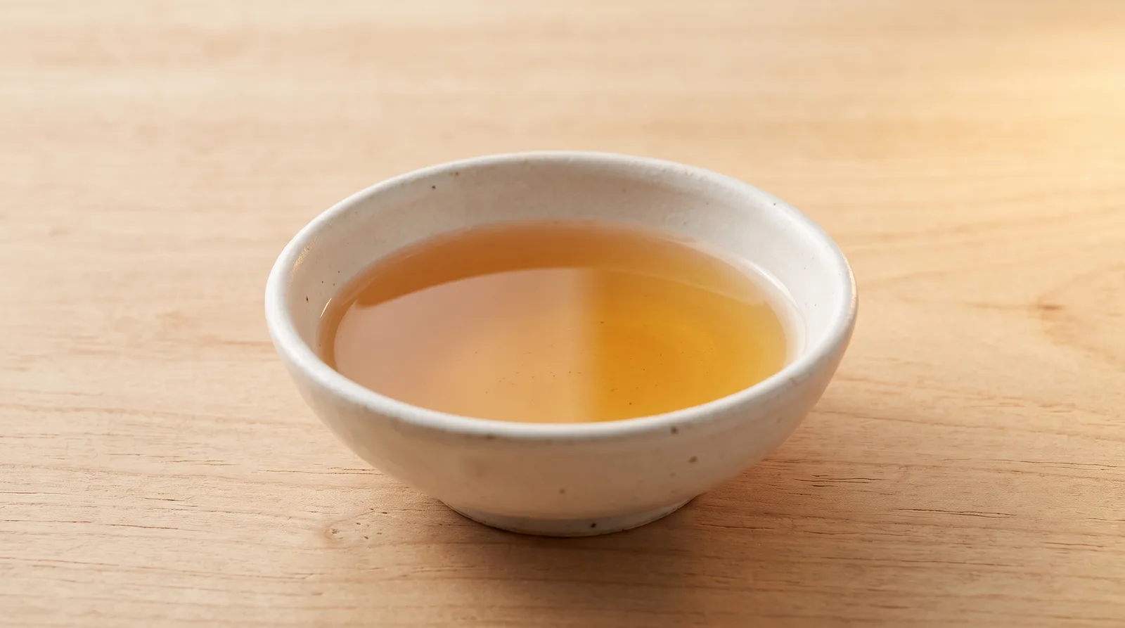 Clarified amber-golden Galactomyces Ferment Filtrate in a shallow white ceramic bowl
